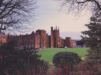 a large building sitting next to a lush green field