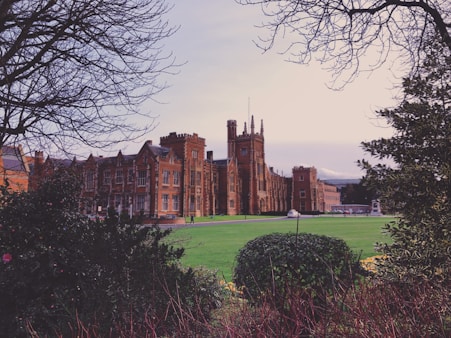 a large building sitting next to a lush green field