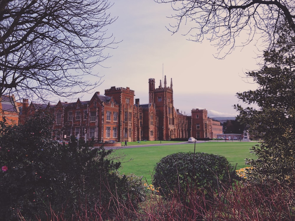 a large building sitting next to a lush green field