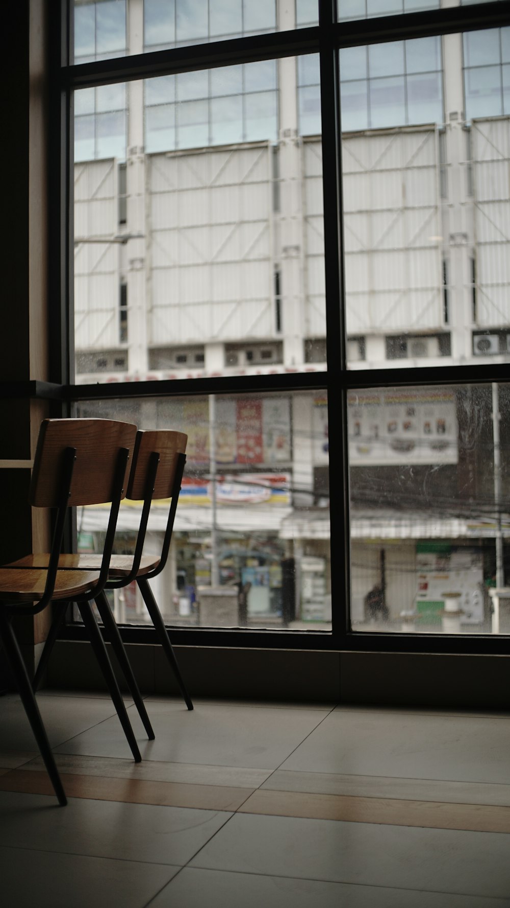 a couple of wooden chairs sitting in front of a window