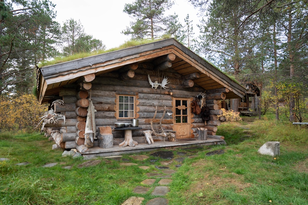 a small log cabin with a green roof