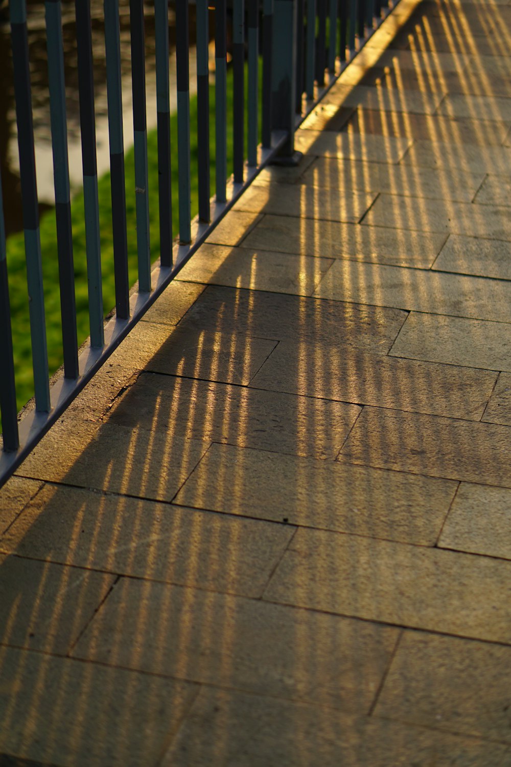 the shadow of a bench on a sidewalk