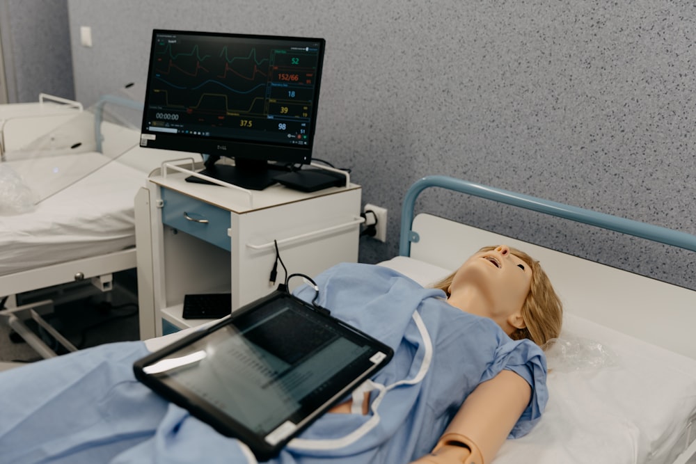 a doll laying in a hospital bed next to a monitor