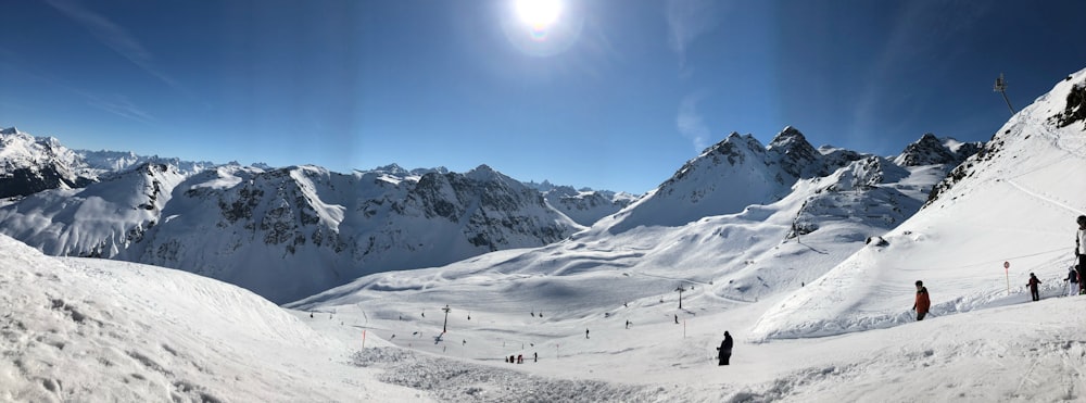 a group of people standing on the side of a snow covered mountain