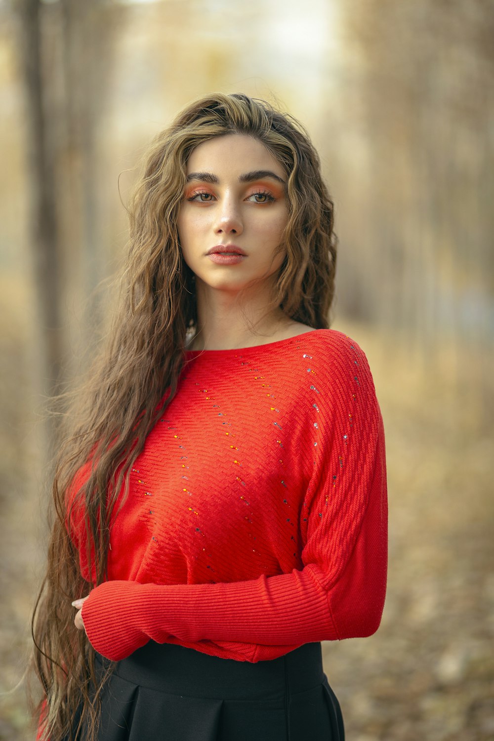 a woman with long hair wearing a red sweater