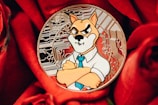 A coin featuring a cartoonish dog character wearing a shirt and tie with a stern expression, set against a background of intricate circuit patterns. The coin is placed on vibrant red roses, creating a contrast between the metallic and organic textures.