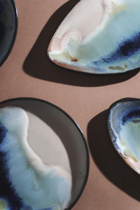A set of handmade plates with warm tones and subtle imperfections, highlighting artisanal charm.
