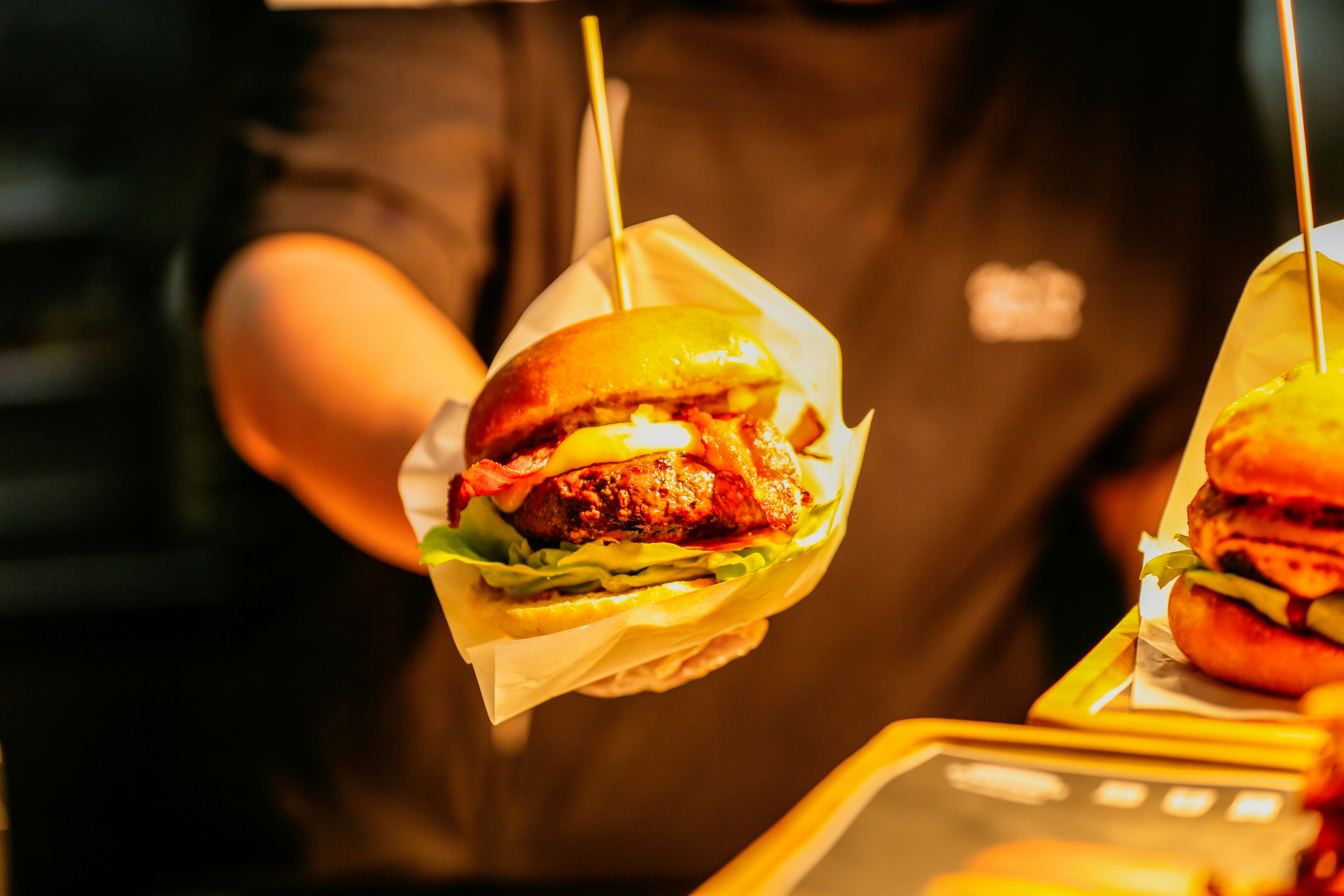 Person holding two gourmet sandwiches