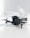 A black quadcopter drone with four propellers is placed on white crumpled paper. The drone features a camera at its front and has red and silver accents on its propellers. The background is a soft white, creating a clean and minimalistic setting.