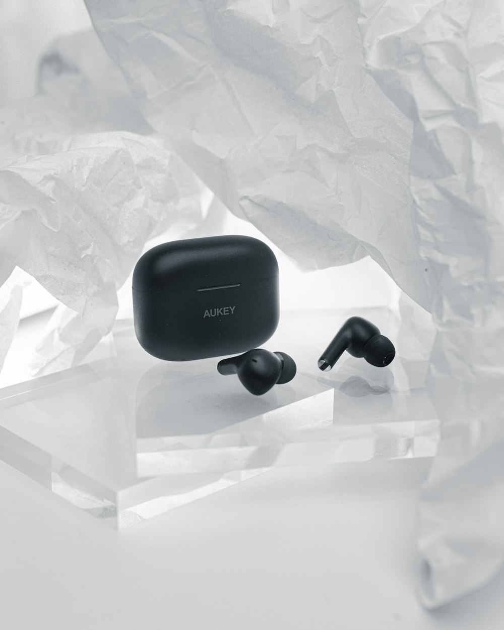 a pair of black ear buds sitting on top of a table