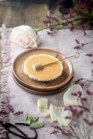 A rustic wooden table displaying an array of natural lip balms with beeswax and honeycomb accents.