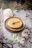 Golden honey drizzling over a rustic wooden table next to blush pink napkins.