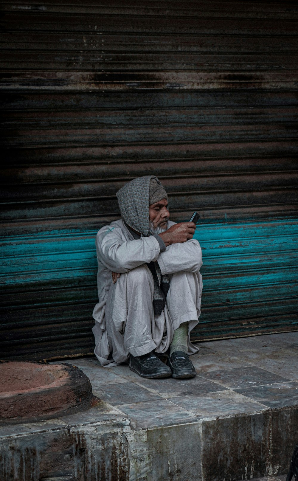 a man sitting on a step looking at his cell phone