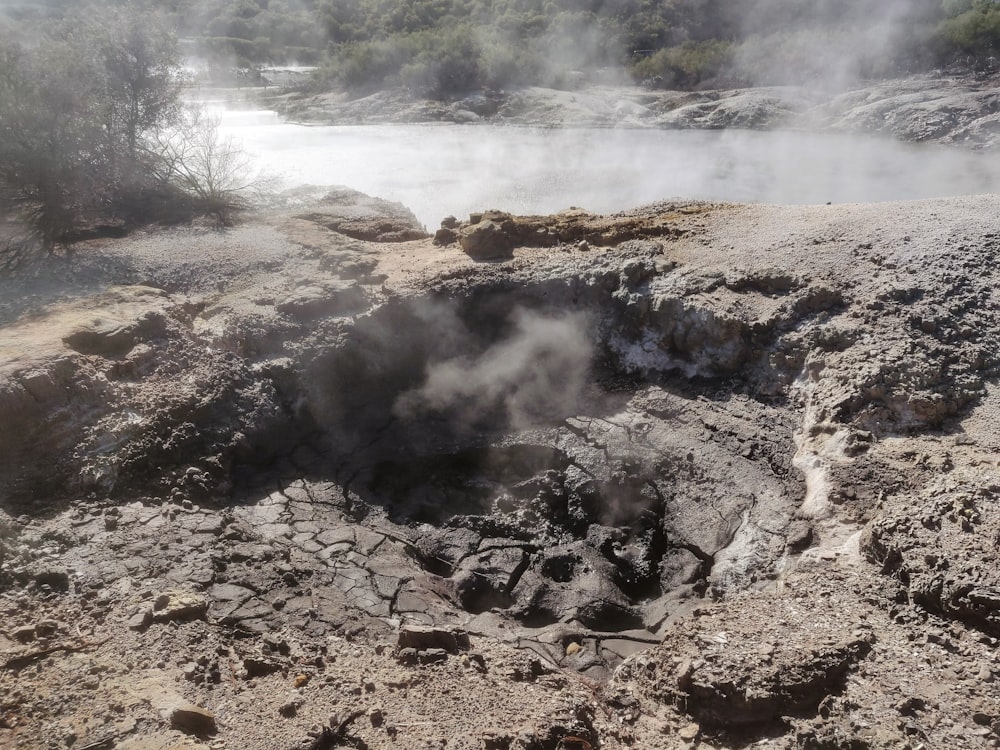 a large hole in the ground with steam coming out of it