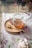 A jar of golden honey with a wooden dipper resting beside it on a rustic table.