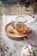 A jar of golden honey with a wooden dipper resting beside it on a rustic table.