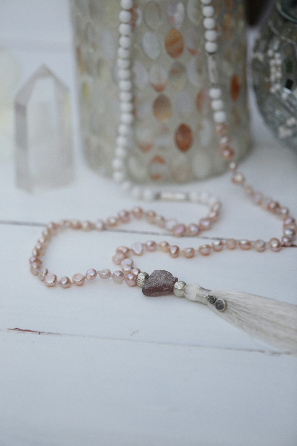 a beaded necklace with a tassel on a table