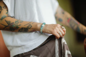 a man with tattoos on his arm holding a bag