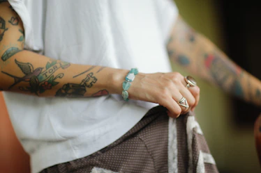 a man with tattoos on his arm holding a bag