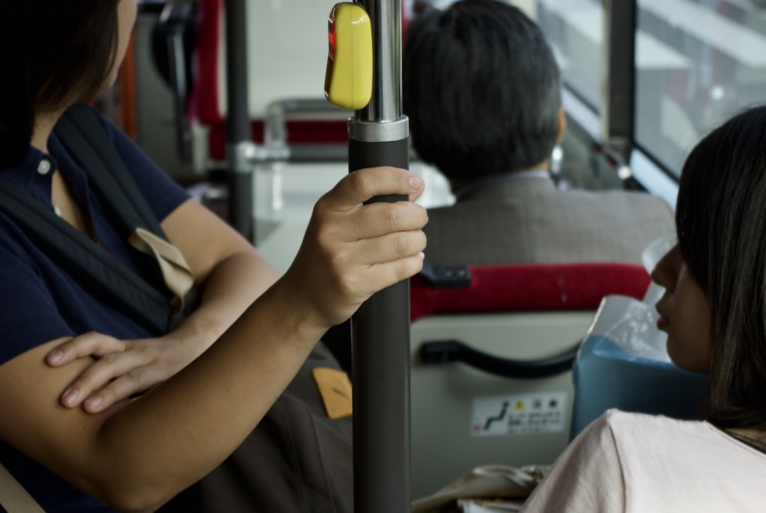 a woman holding a yellow object in her hand, People in a bus
