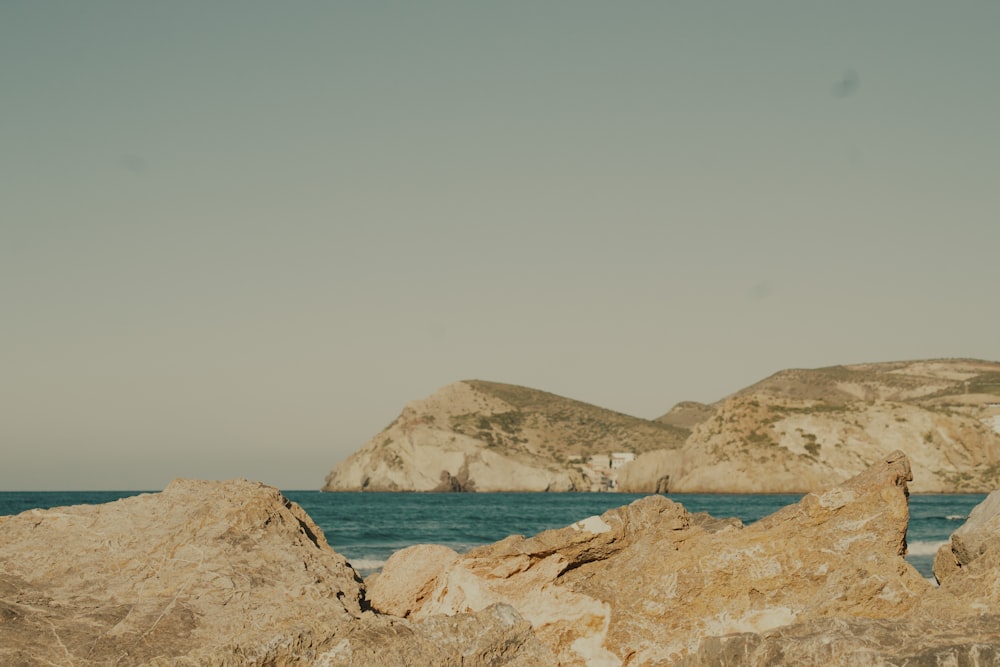 a person standing on rocks near the ocean