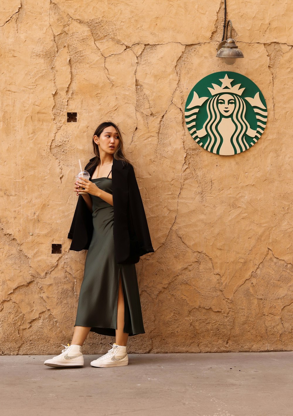 a woman standing in front of a starbucks sign