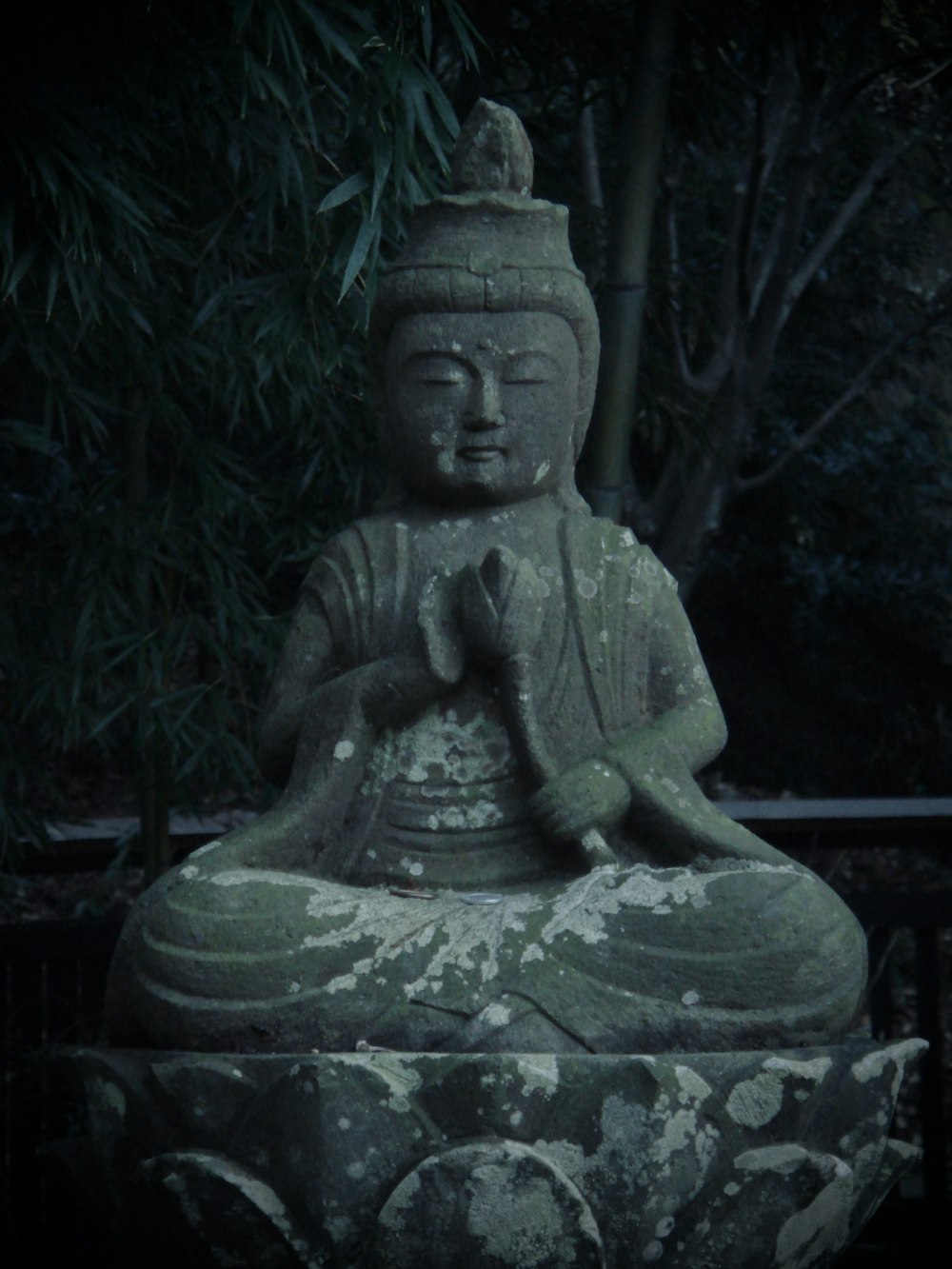 a buddha statue sitting on top of a stone slab