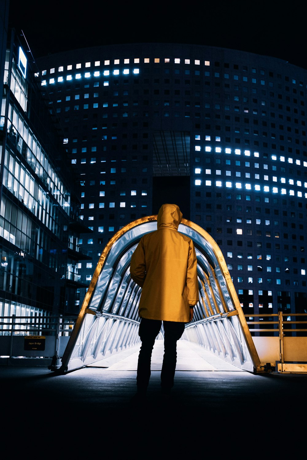 a man in a yellow jacket is standing in front of a building