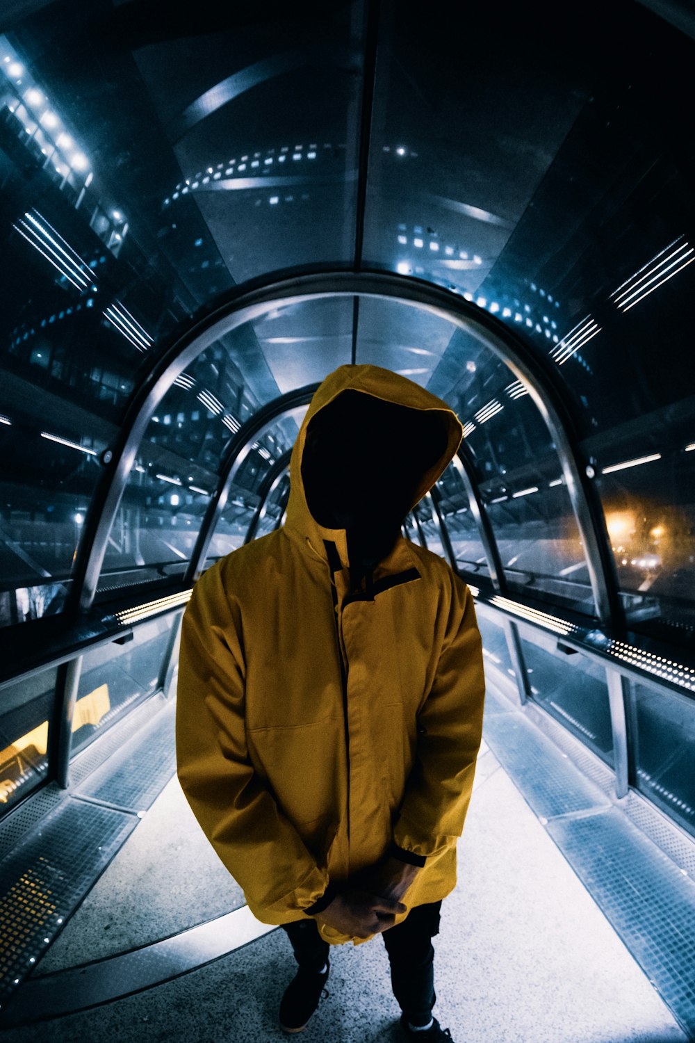 a man in a yellow jacket standing in a tunnel