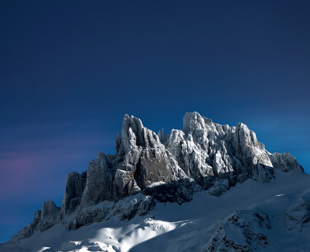 a mountain covered in snow under a blue sky