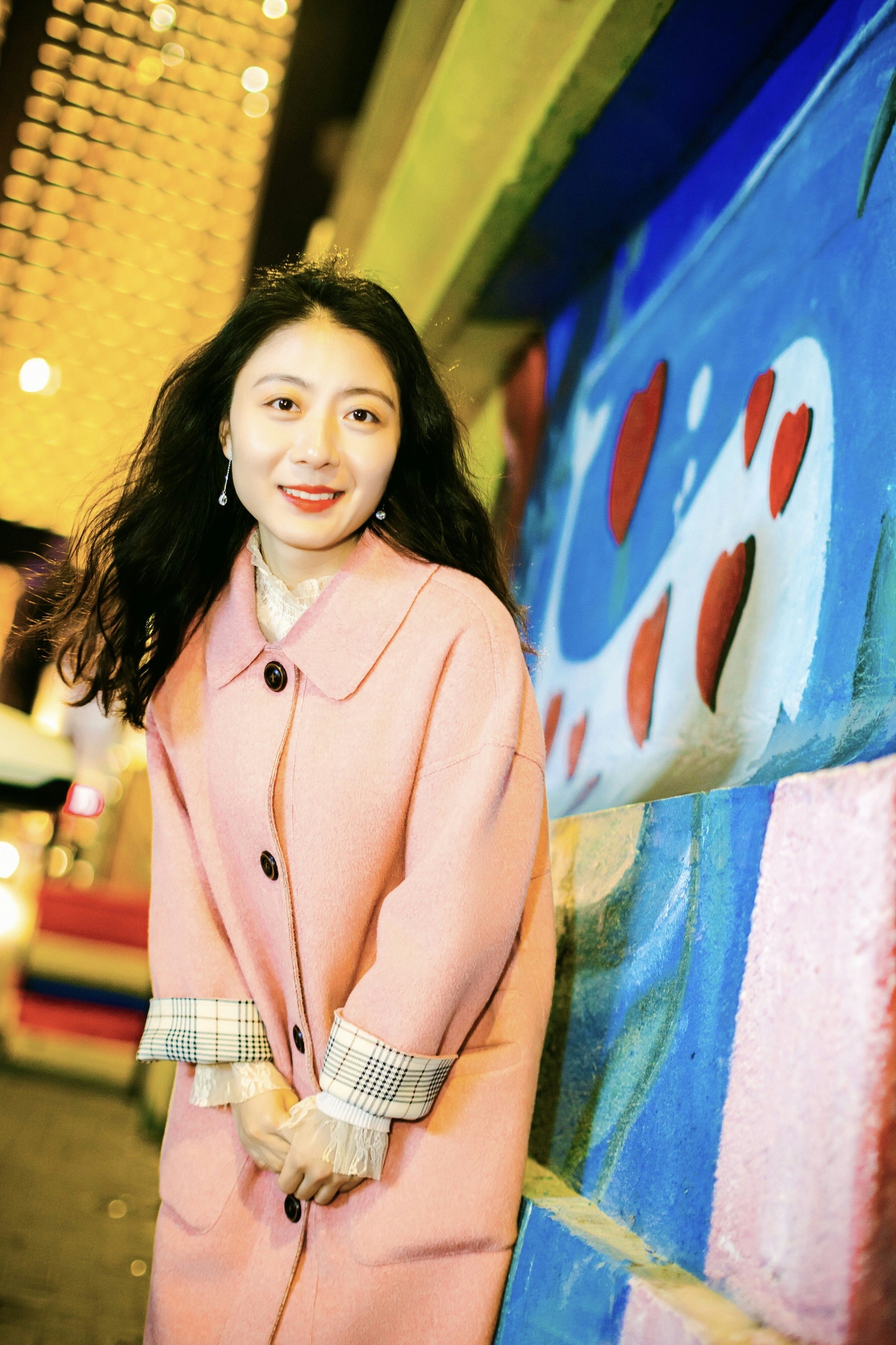 a woman standing in front of a colorful wall