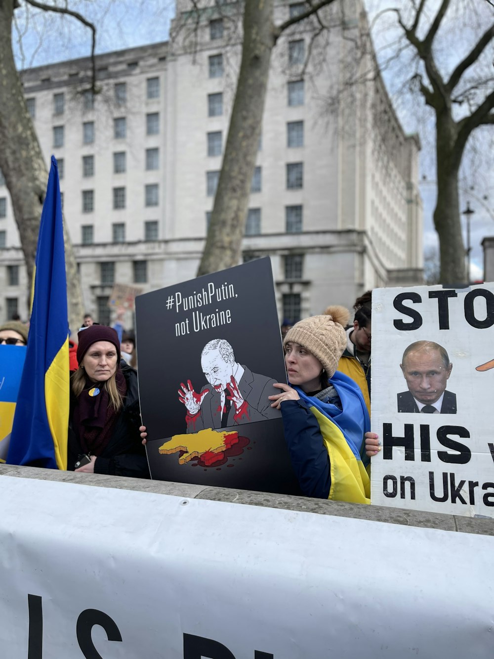 a group of people holding signs in front of a building