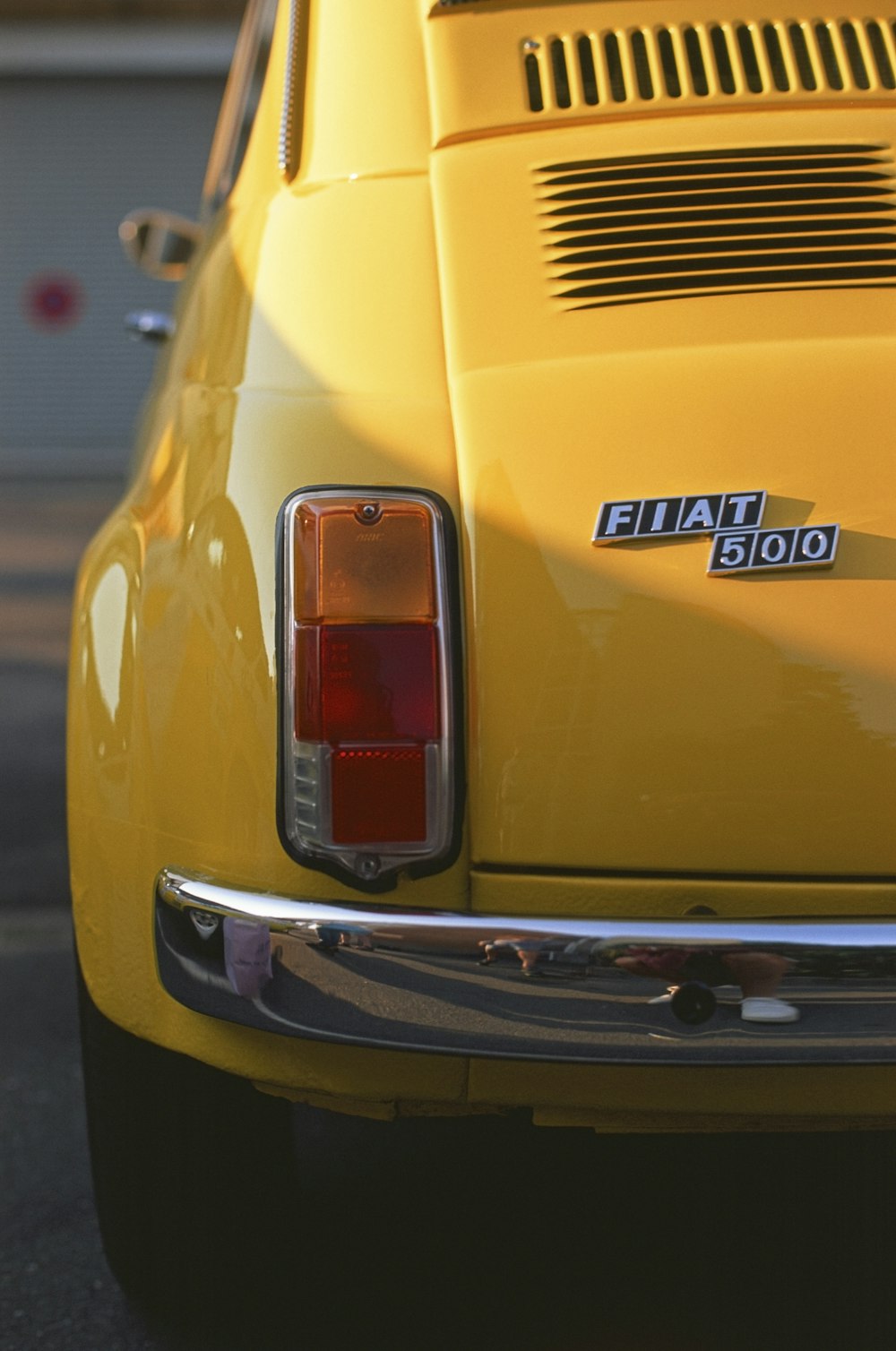 Un primer plano de la cola de un coche amarillo