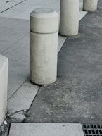a row of cement pillars sitting on the side of a road