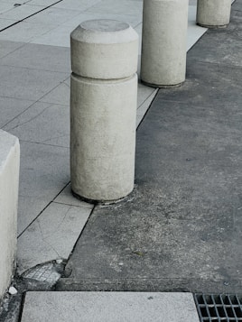 a row of cement pillars sitting on the side of a road