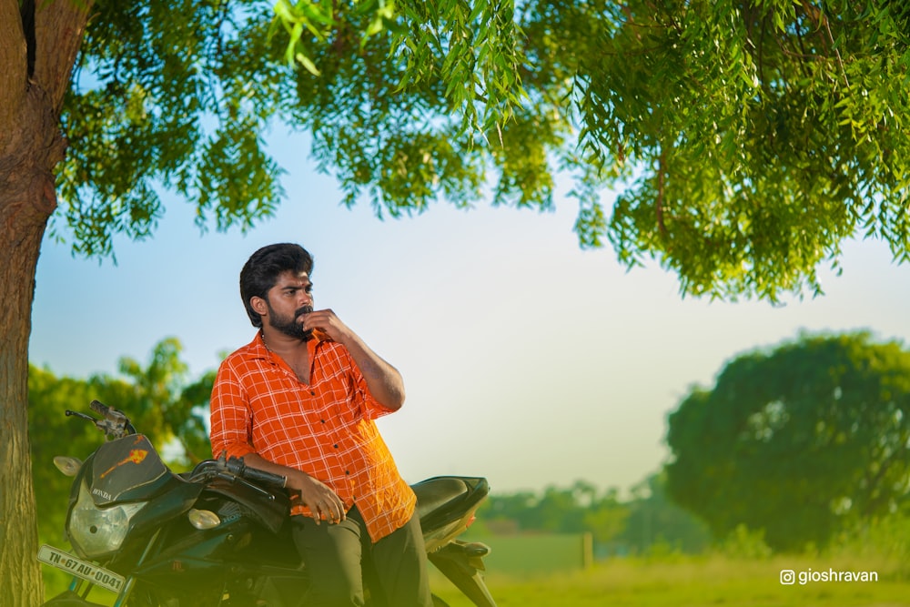 a man sitting on a motorcycle talking on a cell phone