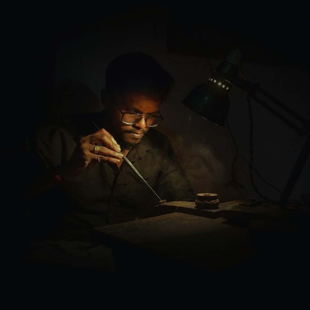 a man sitting at a table working on something