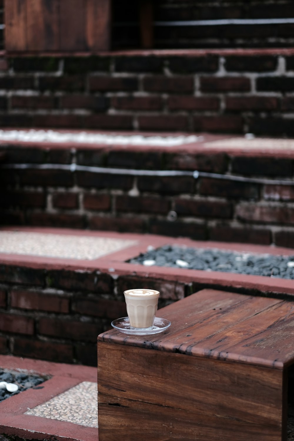 a cup of coffee sitting on top of a wooden table