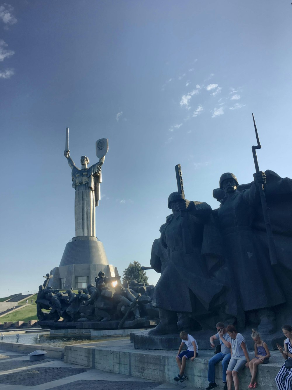 a group of people sitting next to a statue