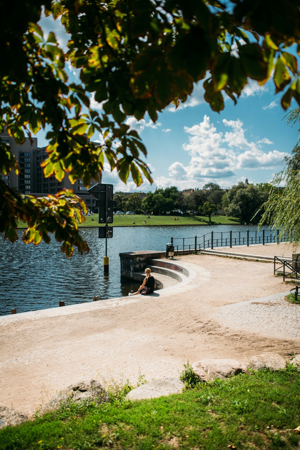 a person sitting on a bench near a body of water