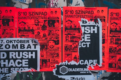 a bunch of posters on the side of a building