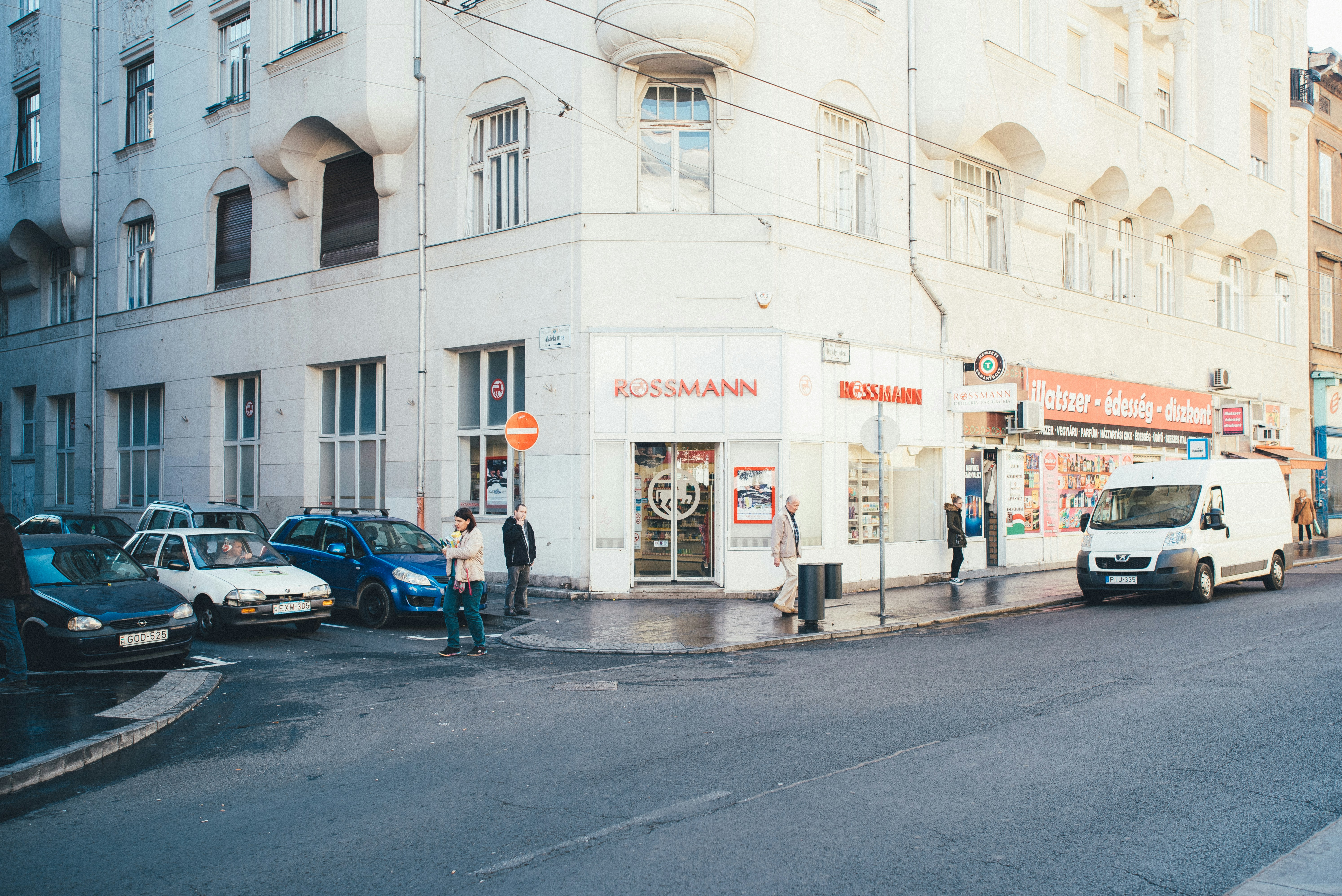 a man standing in front of a store on a street corner