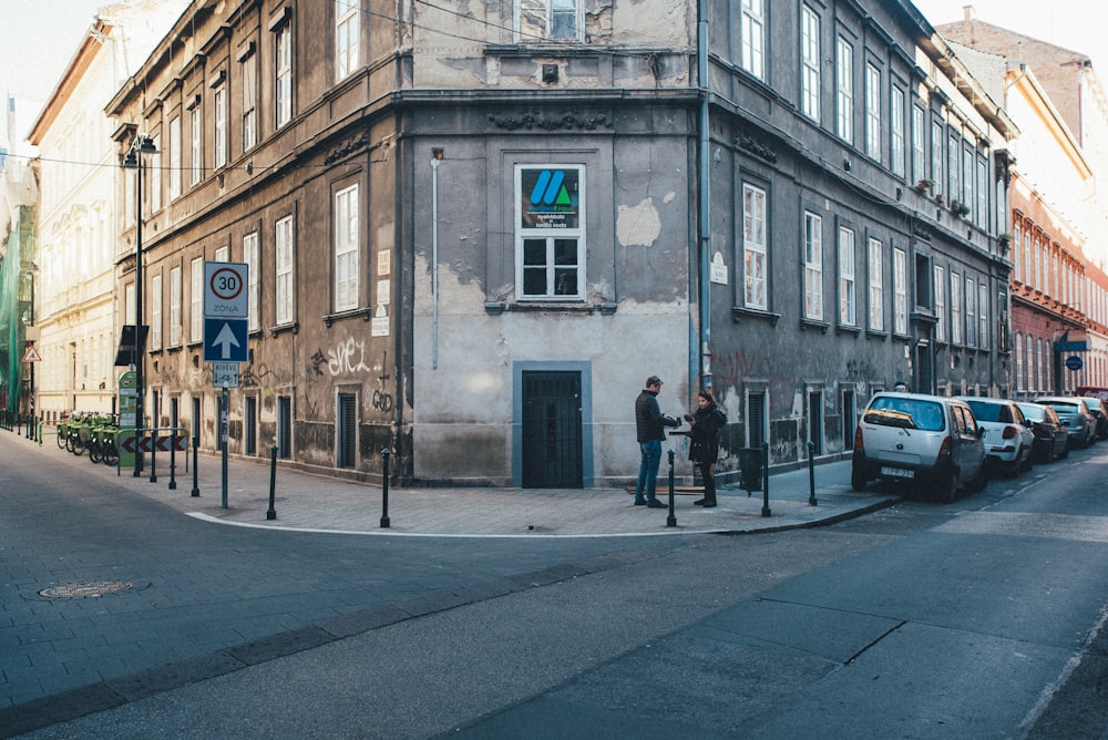 a couple of people that are standing in front of a building