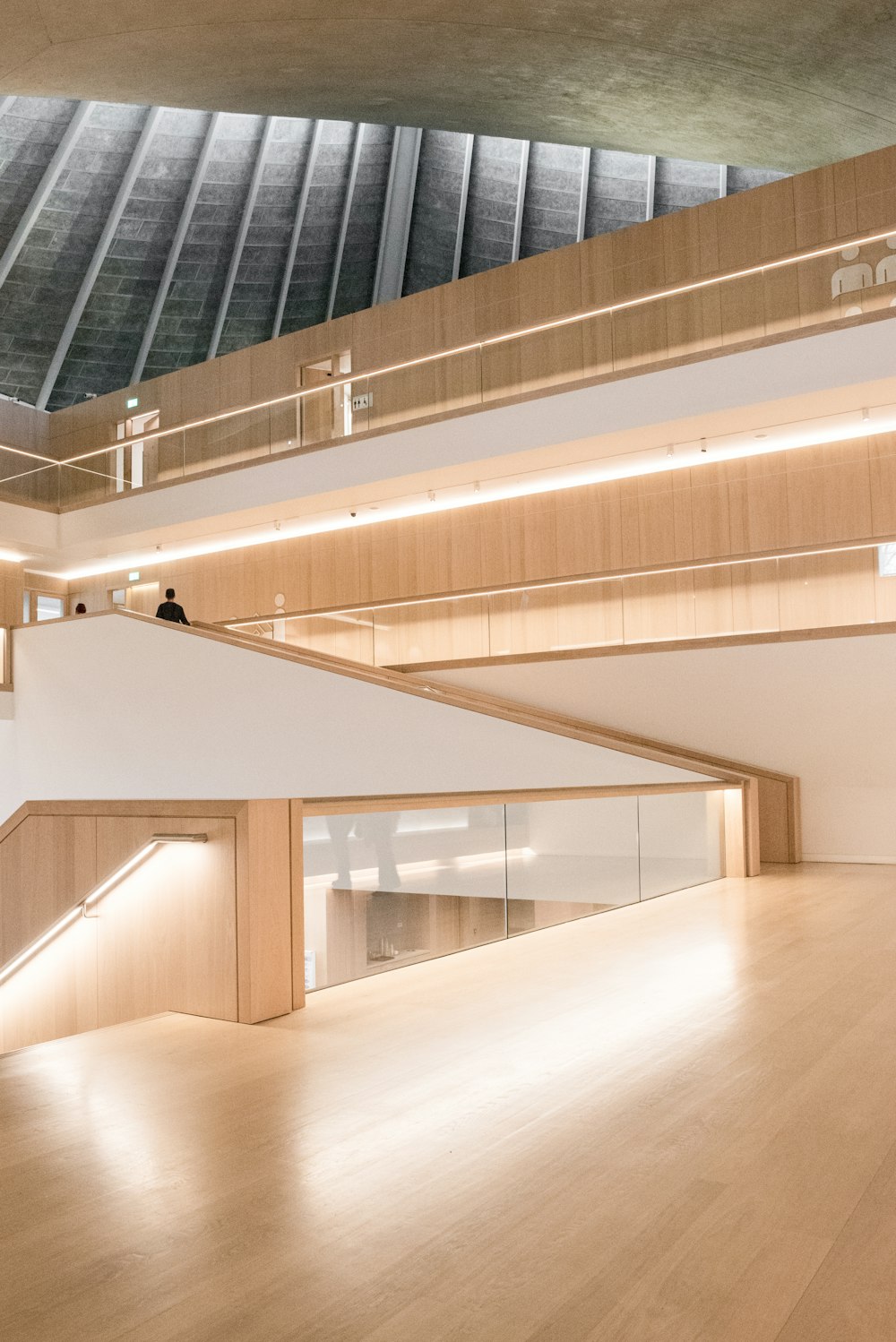 a large room with a staircase and a wooden floor