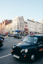 A vialuxe taxi driving past the iconic Birmingham skyline on a sunny afternoon.