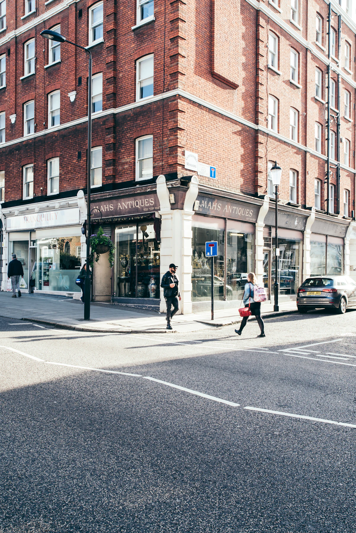 a person crossing a street in front of a tall building