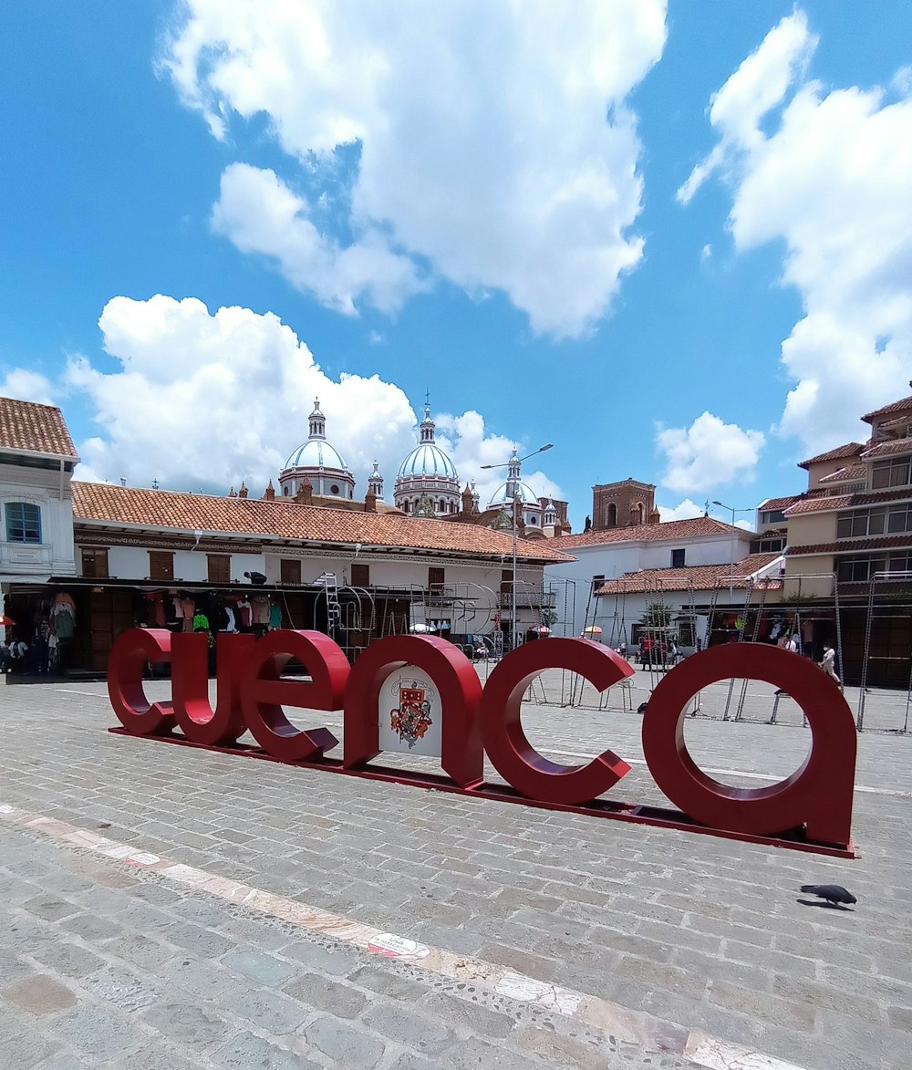 Ein großes rotes Schild mit der Aufschrift Cococo auf einem Platz