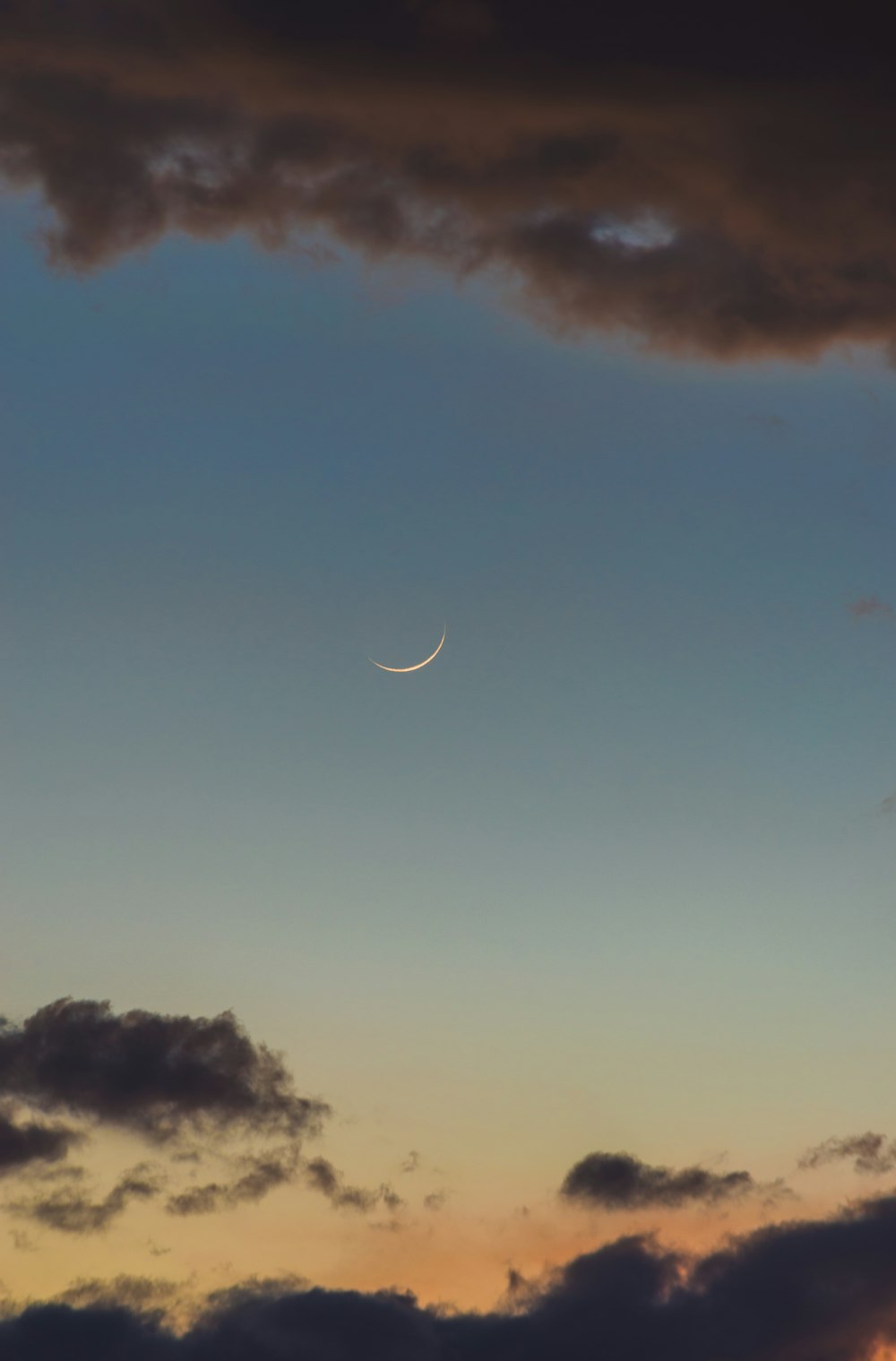 the moon is seen through the clouds in the sky