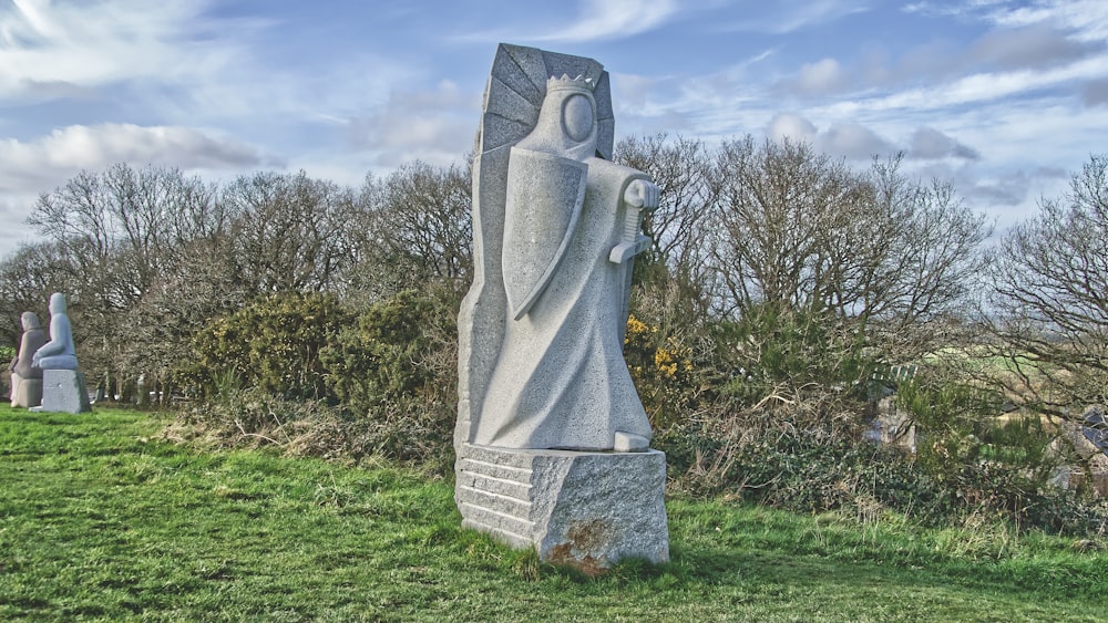 a statue of a woman in a grassy field