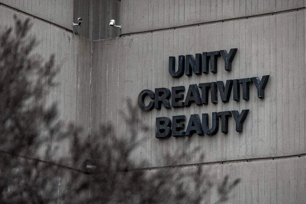 a sign on the side of a building that says, unity creativity beauty